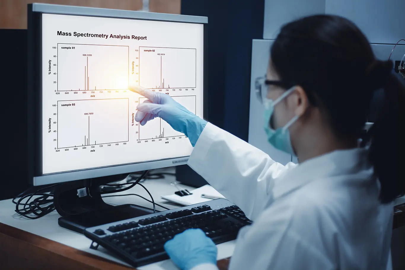 A scientist indicates the compounds in a sample on a chromatogram of mass spectrometry analysis. The computer monitor of displays the results from a mass spectrometer instrument in the laboratory.